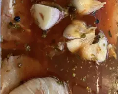 Step <p>Ponemos en un recipiente con tapadera, los trozos de lomo, la cabeza de ajos, cortada por la mitad, la pimienta en grano, el pimentón dulce, el orégano, la sal, el vino y el agua fría hasta cubrir el lomo.</p> illustration